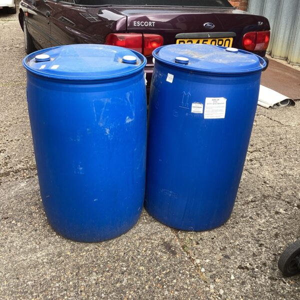 Two large blue plastic barrels beside a car.