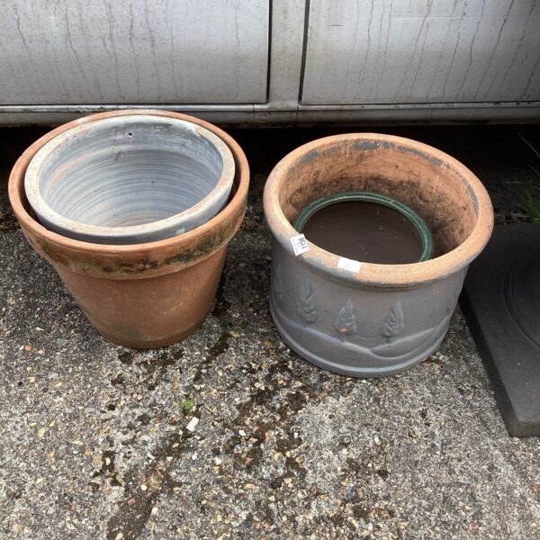 Lot of four weathered terracotta garden pots for outdoor plants.