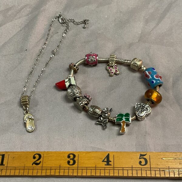 Colourful charm bracelet necklace with floral and heart charms.