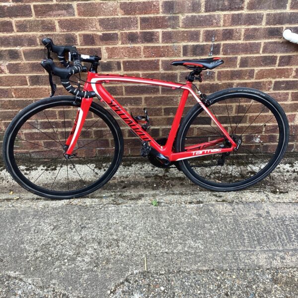 Red Specialized Tarmac carbon racing bike, side view.