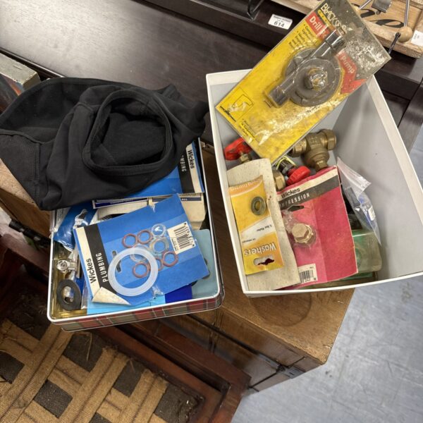 Mixed hardware lot with two metal tins of plumbing and tool parts.