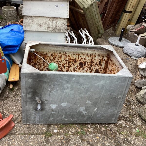 Large galvanised water tank showing signs of weathering and rust.