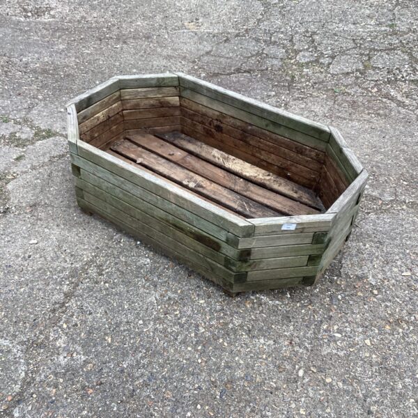 Rustic hexagonal wooden garden planter for outdoor plants.