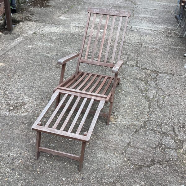 Vintage hardwood garden sun lounger in a garden setting.