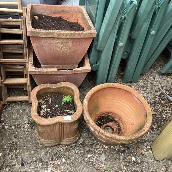 Lot of four terracotta garden pots for outdoor plants.