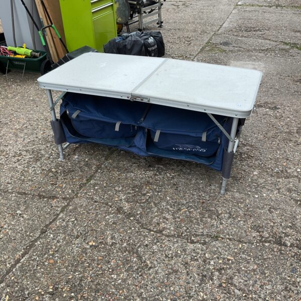 Used trespass folding camping table with storage pockets for outdoor use.