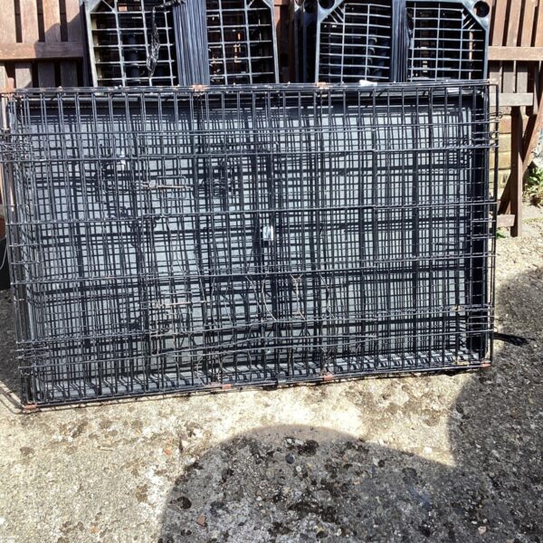 Metal animal transport crate showing signs of use.