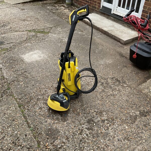 Karcher K4 pressure washer with attachments for garden and patio cleaning.