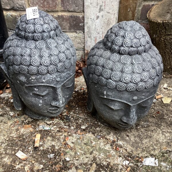 Weathered garden Buddha head pair for outdoor zen decor.