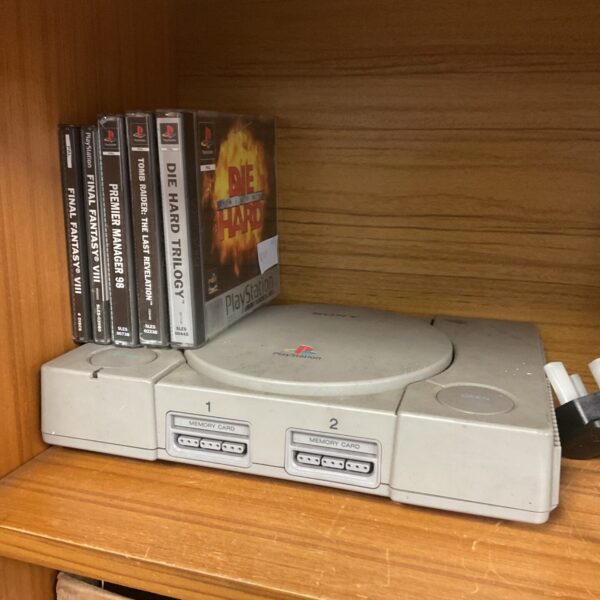 Sony PlayStation console with games, retro gaming collectible.
