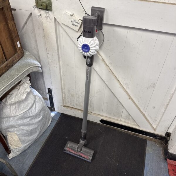 Front view of a grey Dyson V6 cordless vacuum cleaner.