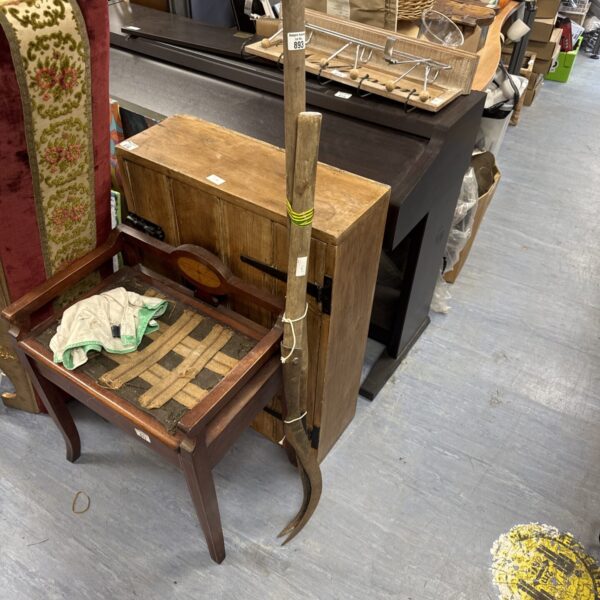 Pair of vintage scythes with wooden handles and curved blades.