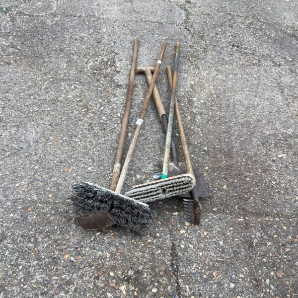 Vintage cleaning tools lot with wooden handles and worn bristles.