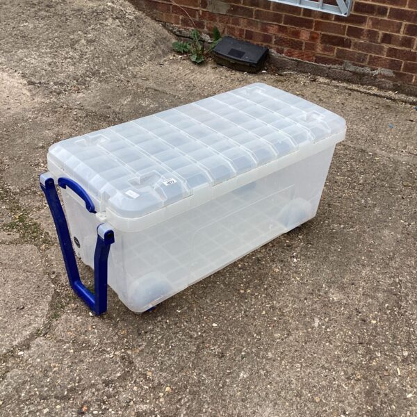 Large plastic storage box on wheels for home storage.