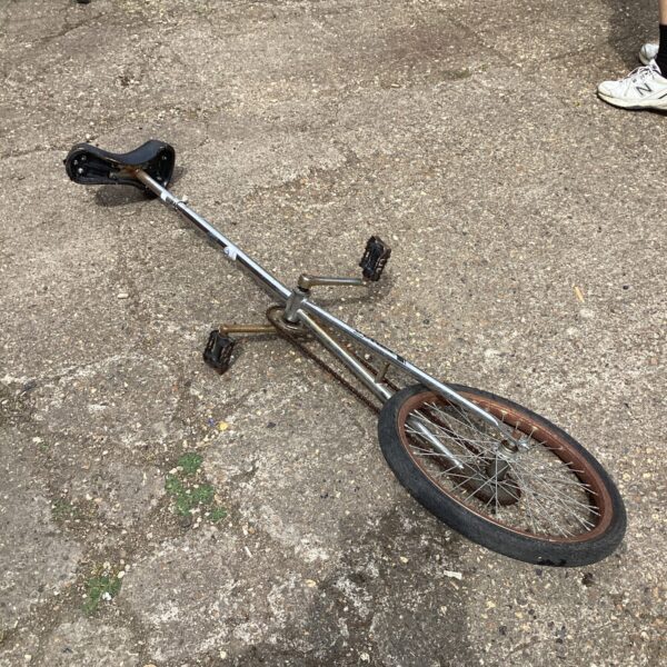 Vintage Reflex unicycle with a single wheel and metal frame.