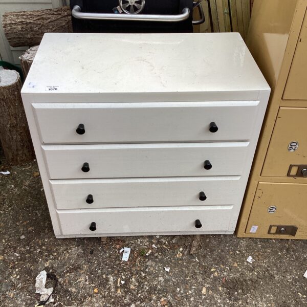 Vintage white drawers with black knobs, retro bedroom storage.