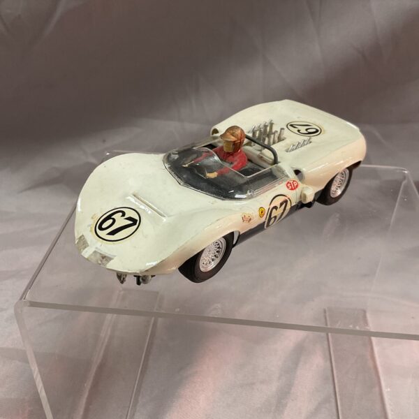 Side view of vintage Cox Chaparral slot car with number 67.