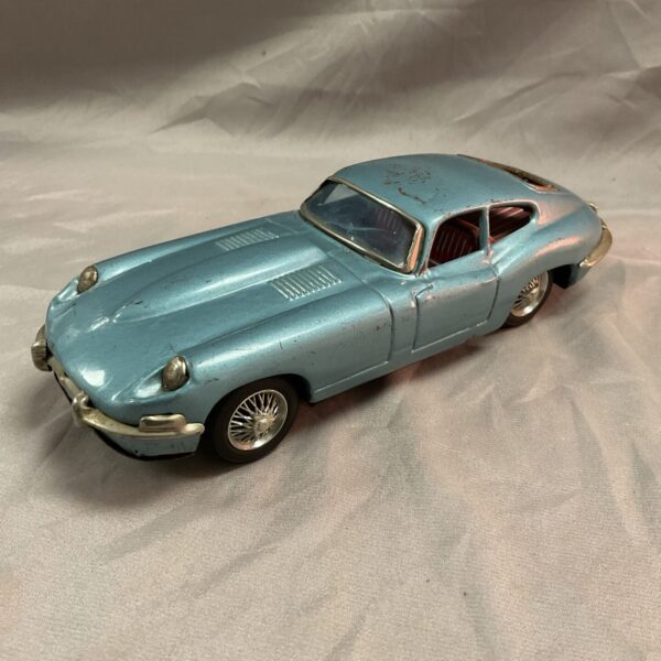 Side view of a vintage Japanese tin Jaguar XK-E car.