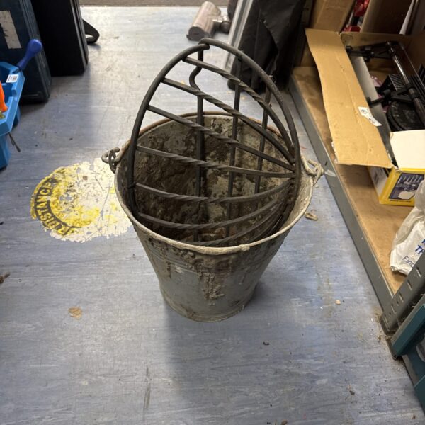 Vintage galvanised bucket with wrought iron flower holder for garden display.