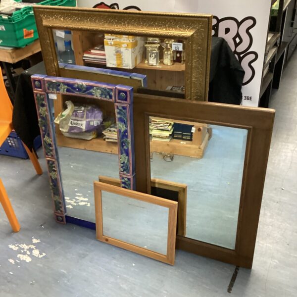 Large gilt framed mirror with ornate detailing.