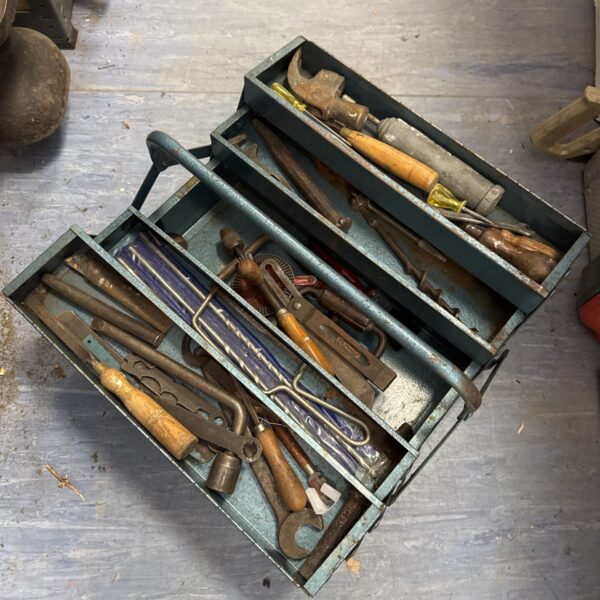Vintage metal cantilever toolbox filled with antique tools.