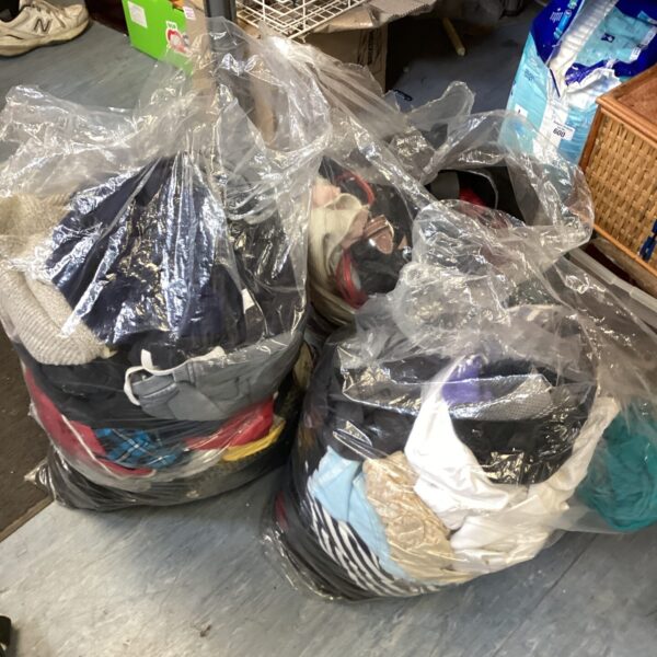 Three bags filled with a mixed clothing lot for resale.