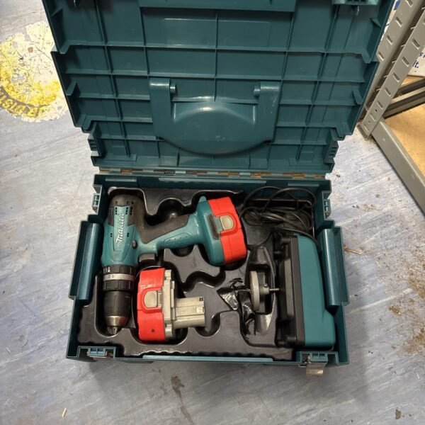 Makita cordless drill in open carrying case, showing batteries and charger.