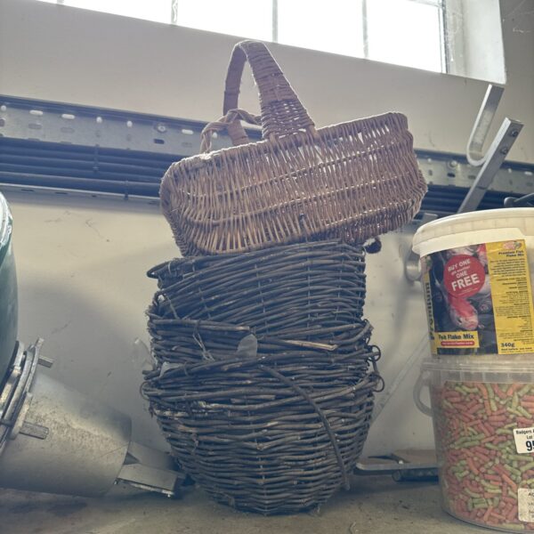 Stack of three woven hanging baskets for garden plants.