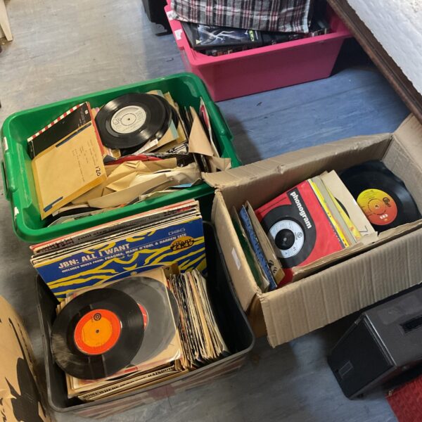 A lot of vintage 7 inch vinyl records in boxes.
