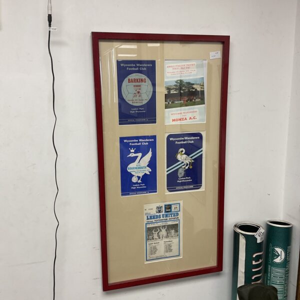 Framed vintage football programme collection featuring Wycombe Wanderers and Leeds Utd.
