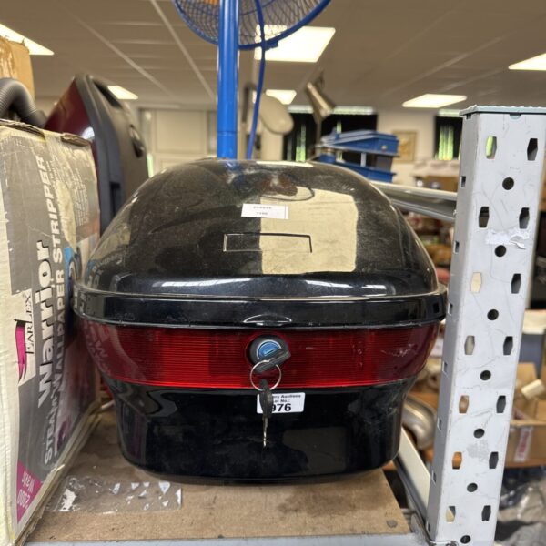 Black motorcycle pillion box with keys for secure storage.