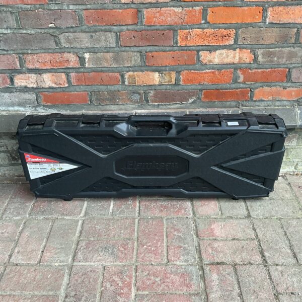 Black Flambeau gun case against a brick wall background.