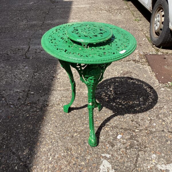 Vintage green metal garden table in an outdoor setting.