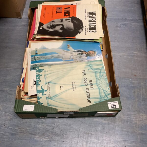 Tray of vintage 1950s sheet music, collectible song sheets.