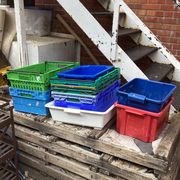 Stack of colourful plastic storage crates for household organisation.