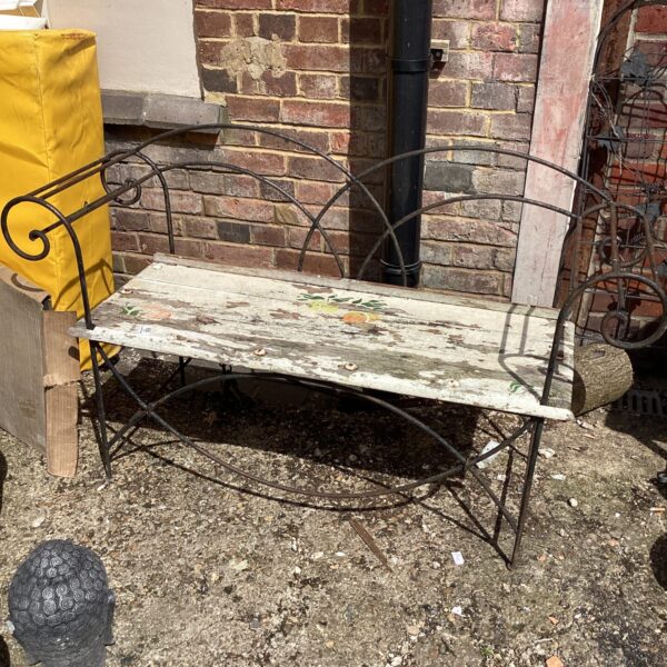 Weathered vintage metal garden bench with wooden slats.