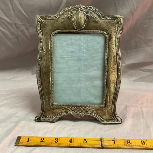 Antique Art Nouveau silver photo frame with intricate floral design.
