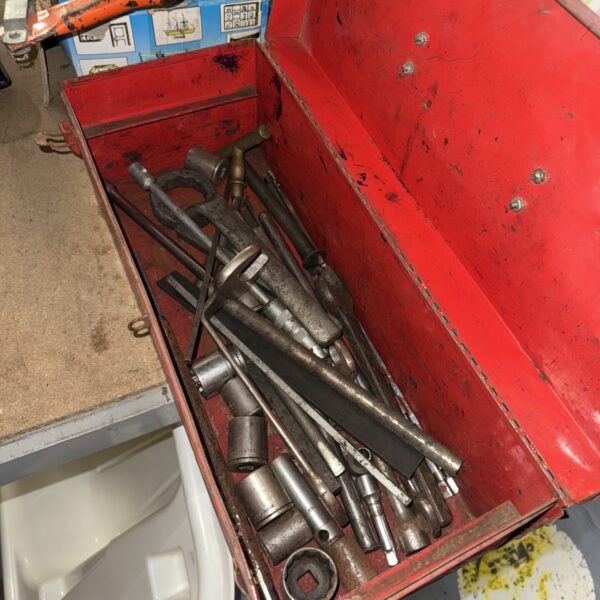 Vintage metal toolbox filled with various hand tools for workshop storage.