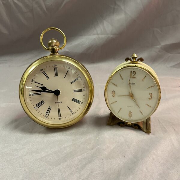 Vintage Swiza travel clocks with gold cases and dials.