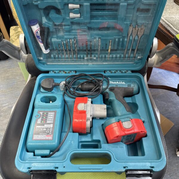 Makita cordless drill set in open carry case with batteries and charger.