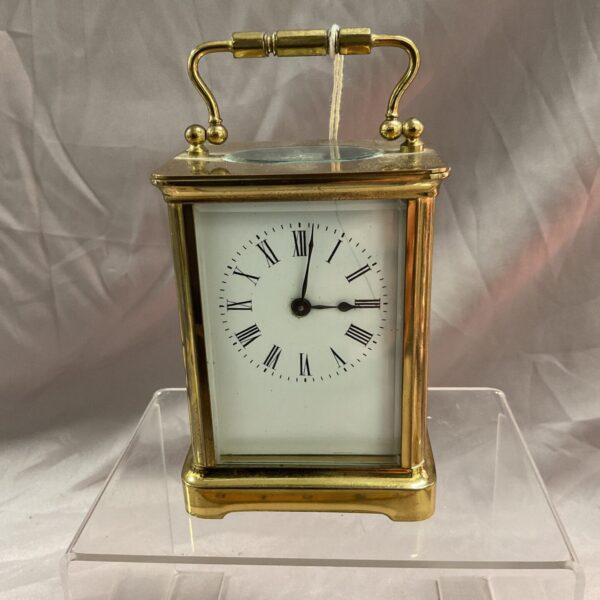 Antique brass carriage clock with white enamel dial.