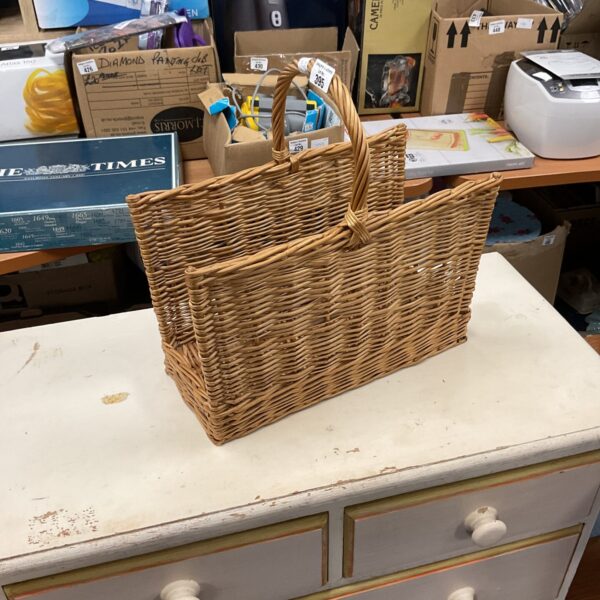 Vintage wicker magazine rack for storing magazines and newspapers.