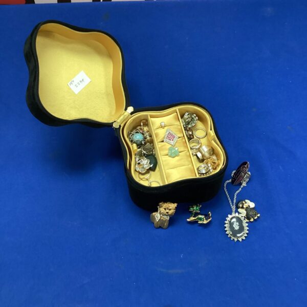 Vintage jewellery box filled with assorted costume jewellery pieces.
