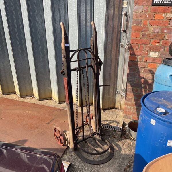 Antique Victorian railway luggage barrow with arched frame.