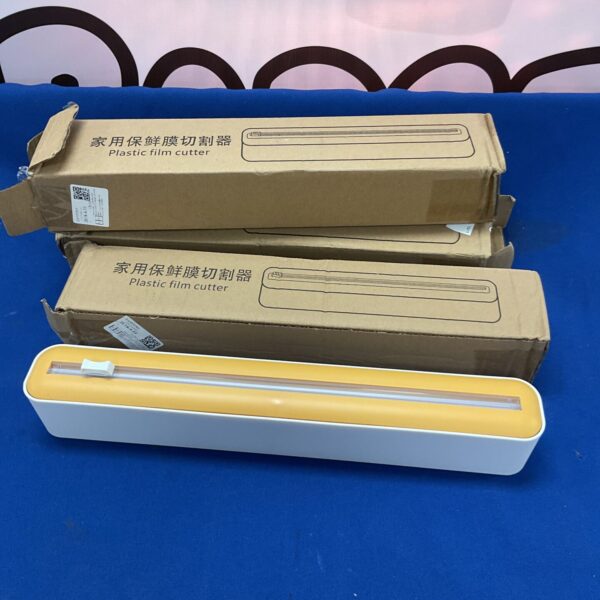 Lot of three new plastic film cutters in packaging.