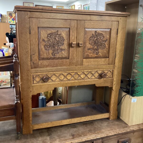 Antique Arts and Crafts oak cabinet with carved details.