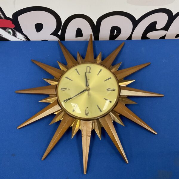 Vintage Metamec sunburst clock with wooden and brass rays.