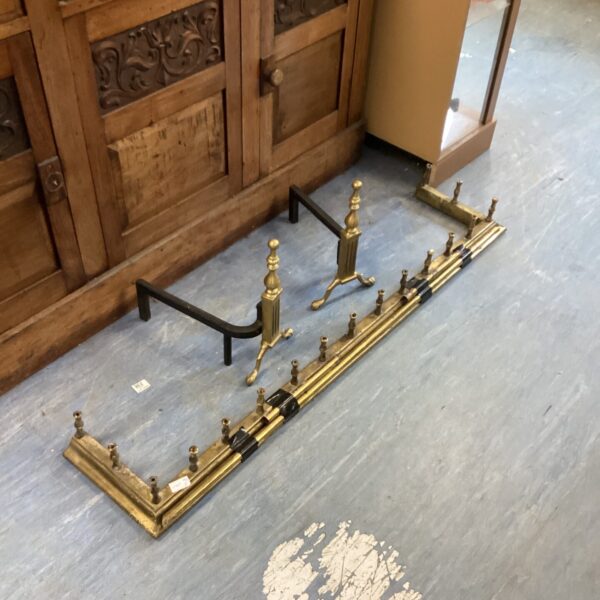 Vintage brass fire fender and andirons for a classic fireplace.