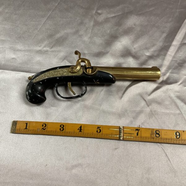 Vintage pistol petrol lighter, detailed metalwork, collectible item.