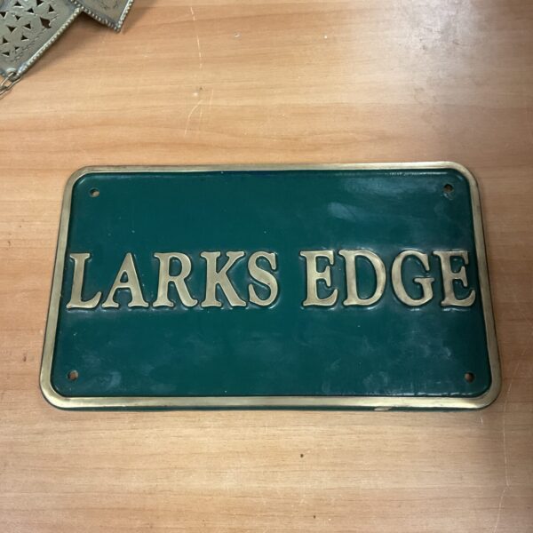 Vintage brass larks edge plaque with intricate detailing.
